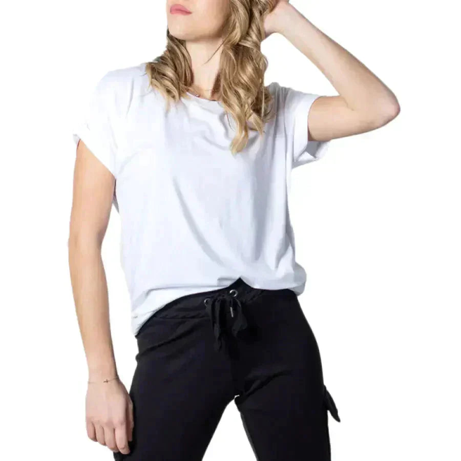 Woman in women’s tops collection, white top and black pants