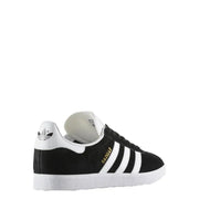 Black and white adidas gazelle sneaker with gold accents.