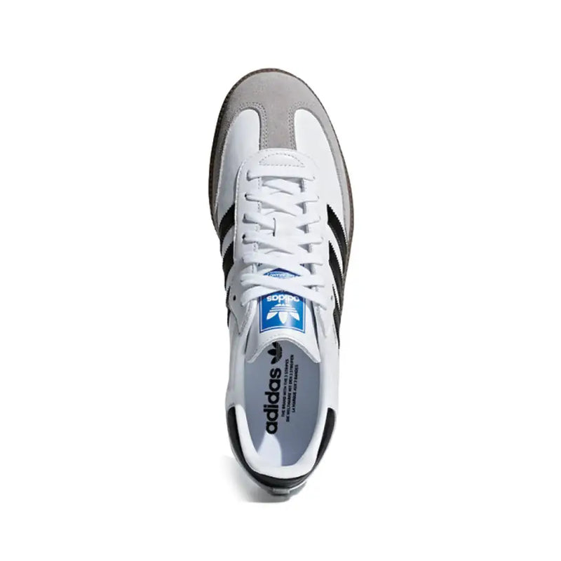 Weißer adidas Samba Ledersneaker mit schwarzen drei Streifen, grauer Wildleder-Zehenkappe, Fersenlasche und blauem adidas Logo auf der Zunge