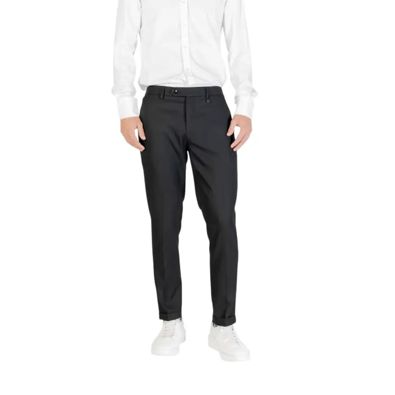 Men’s black slim-fit dress pants paired with a white button-up shirt and white sneakers