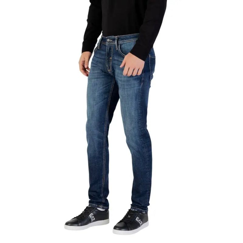 Dark blue slim fit jeans with distressed details and a popular brand logo on the back pocket.