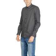 Men’s black and white patterned long-sleeve cotton shirt paired with blue jeans