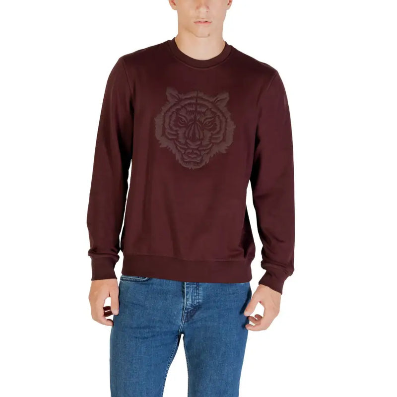 Men’s maroon sweatshirt with embroidered tiger head design paired with blue jeans