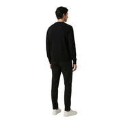 Antony Morato Herrenhose kombiniert mit einem schwarzen Rundhalspullover mit langen Ärmeln und einer glatten, figurbetonten Silhouette