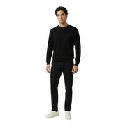 Antony Morato Herrenhose kombiniert mit einem schwarzen Strickpullover mit dezentem, gesticktem Logo auf der linken Brust.