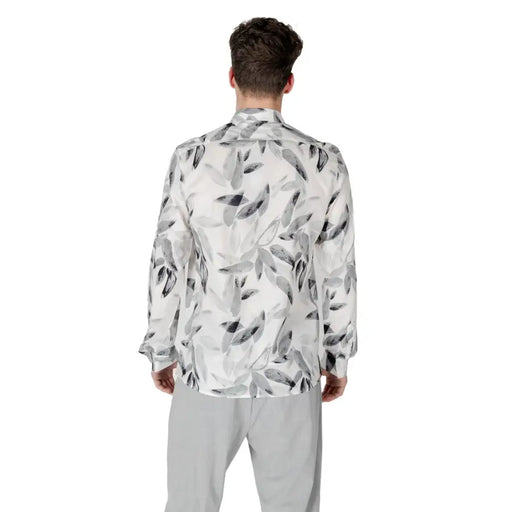 Men’s white floral long-sleeve shirt with leaf pattern paired with light grey pants