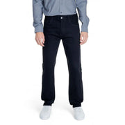 Men’s dark blue jeans paired with a light blue long-sleeved shirt and white sneakers