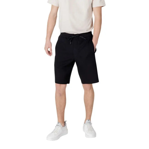 Black drawstring shorts with pockets and white sneakers