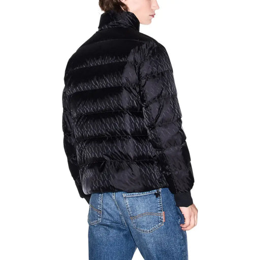 Black quilted down jacket with high collar and ribbed cuffs.