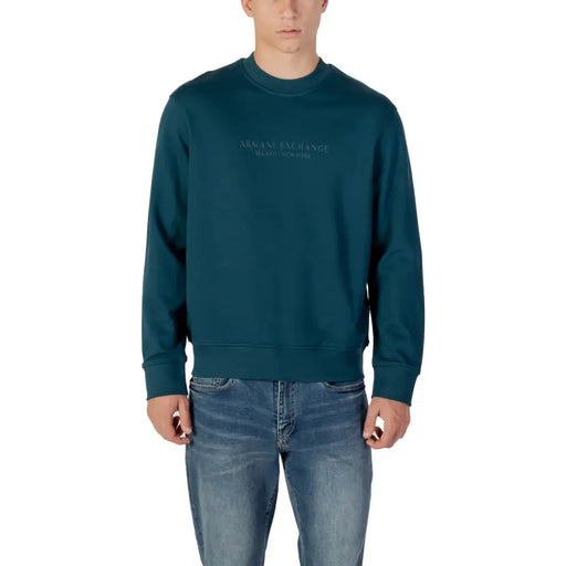 Dunkeltürkisfarbenes Herren-Sweatshirt mit langen Ärmeln und Rundhalsausschnitt, kombiniert mit blauen Jeans von Armani Exchange
