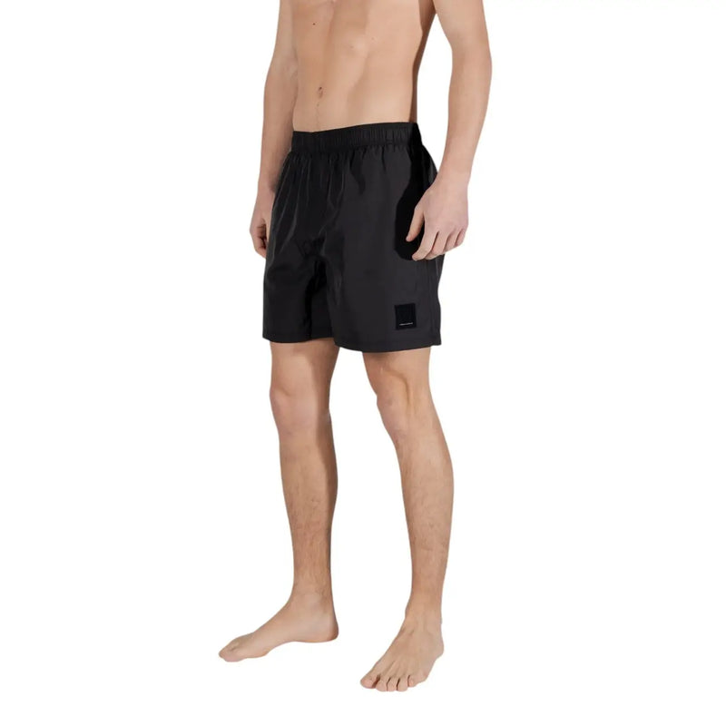 Armani Exchange men black polyester swim trunks with sleek minimalist design and rectangular brand patch on lower right leg