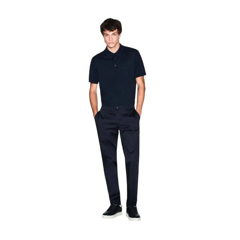 Ein Mann, der einen Armani Exchange Herren-Poloshirt aus blauer Baumwolle mit kurzen Ärmeln und dezentem, gesticktem Logo auf der Brust