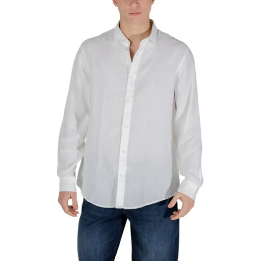 Weißes Herren-Langarmhemd mit Knöpfen, kombiniert mit blauen Jeans für einen frühlings- und sommerlichen Look