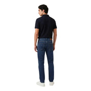 Dunkelblaue Jeans mit fünf Taschen und braunem Lederpatch, kombiniert mit armani exchange blaues Herren-Polohemd mit Reißverschluss