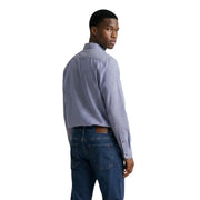 Ein Mann, der einen Armani Exchange Herrenhemd im blau-weiß gestreiften, langärmeligen Button-Down-Stil