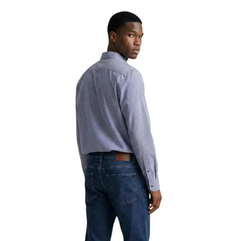 Ein Mann, der einen Armani Exchange Herrenhemd im blau-weiß gestreiften, langärmeligen Button-Down-Stil