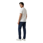 Ein Mann, der einen Armani Exchange weiße Baumwolle t-shirt kombiniert mit dunkelblauen Jeans im lässigen Stil