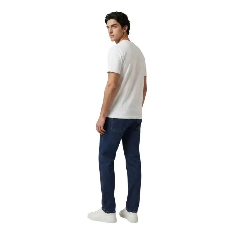 Ein Mann, der einen Armani Exchange weiße Baumwolle t-shirt kombiniert mit dunkelblauen Jeans im lässigen Stil