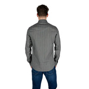 Ein Mann, der einen Armani Exchange Schwarzes Herren-Langarmhemd aus Baumwolle mit geometrischem Muster und dezentem Design