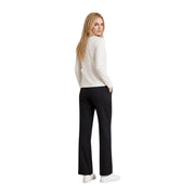 Eine Frau trägt eine Armani Exchange Beigefarbenes Baumwoll-T-Shirt mit Strasssteinen für Damen, kombiniert mit schwarzer Hose und weißen Sneakers