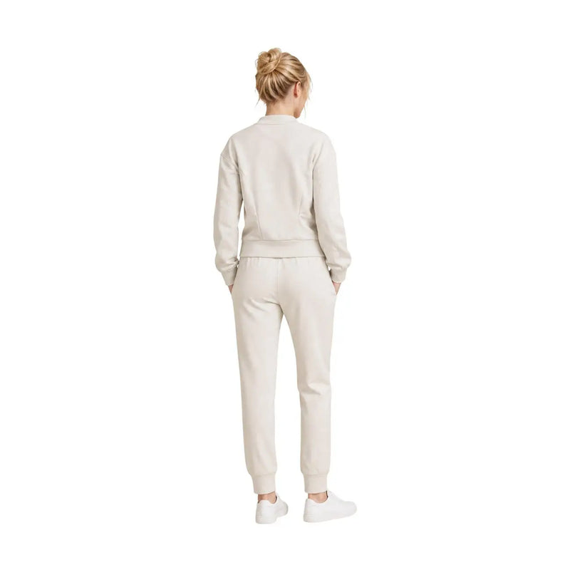 A woman wearing a beige Armani Exchange women sweatshirt and jogger pants with ribbed cuffs in viscose blend