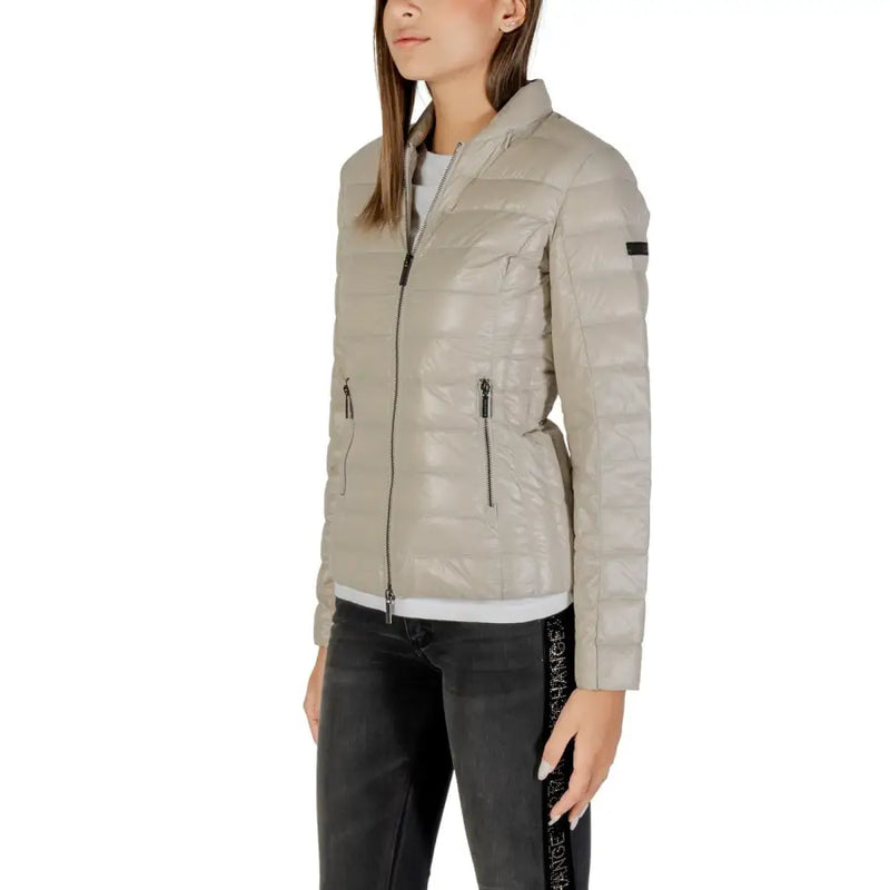 Woman wearing Armani Exchange beige quilted puffer jacket with high collar and zippered pockets