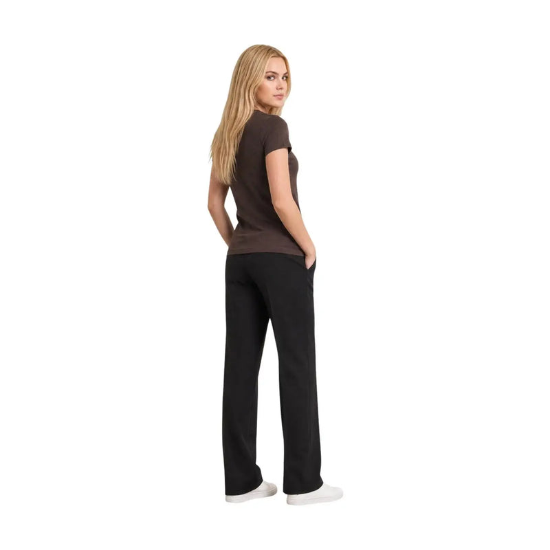Eine Frau trägt eine Armani Exchange Damen-T-Shirt aus brauner Baumwolle mit V-Ausschnitt und Pailletten, kombiniert mit schwarzer Hose mit geradem Bein