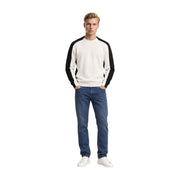 Armani Exchange Herren-Wollpullover in Creme und Schwarz mit Raglanärmeln und Rundhalsausschnitt, getragen vom Model mit blauen Jeans