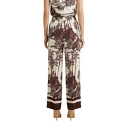 Cremefarbene Seidenhose mit weitem Bein, auffälligem braunem Tropenmuster und gestreiften Bündchen aus der Frühjahr/Sommer-Kollektion von Artigli.
