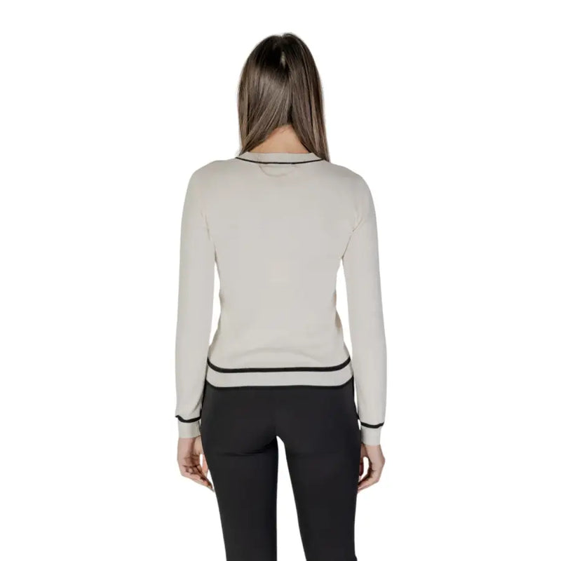 Beige long sleeve knit cardigan with off-white fabric black trim and front pockets in a sleek design