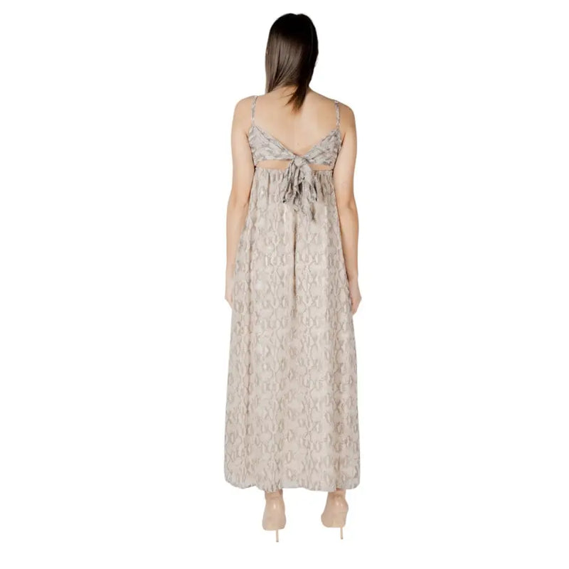 Beige sleeveless maxi dress with snake print pattern thin straps and back tie detail shown from the back side