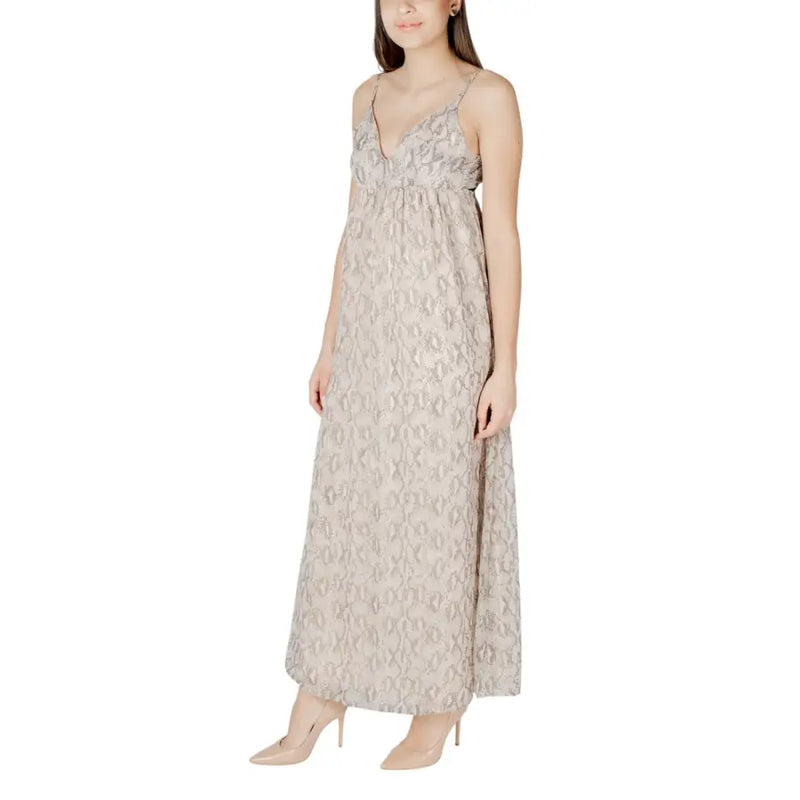 A flowing beige sleeveless maxi dress with silver snake print pattern and delicate spaghetti straps