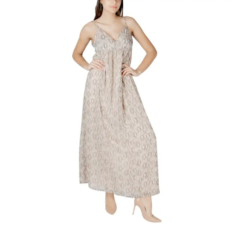 A flowing beige patterned sleeveless maxi dress with taupe lace fabric delicate spaghetti straps and a v-neckline