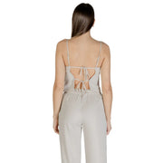 A light gray satin jumpsuit with thin straps and back tie detail complementing a beige sleeveless round neck polyester top