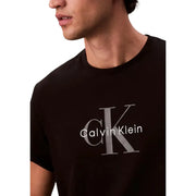 Black Calvin Klein t shirt in cotton featuring a prominent silver CK logo and brand name printed across the chest