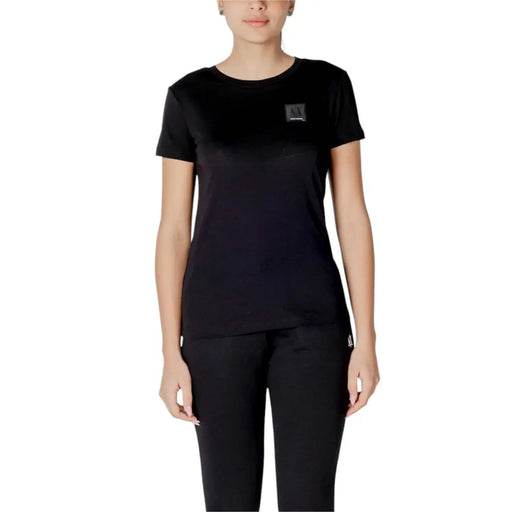 Black crewneck t shirt made of cotton featuring a black short-sleeved design with a small rectangular logo patch on the chest