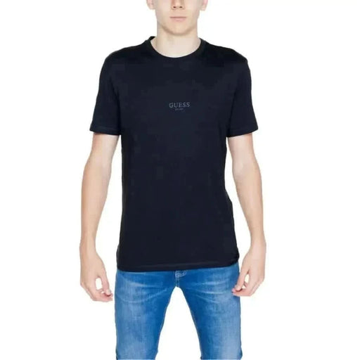 Guess Männer T-Shirt in Schwarz, getragen vom Model mit blauen Jeans