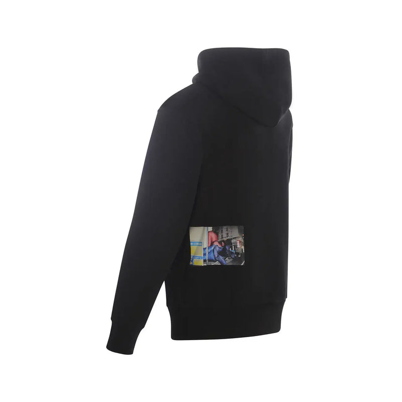 Black hooded sweatshirt featuring a rectangular photographic print on the lower back in a sleek black fabric