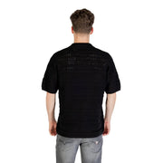Black knit polo shirt showing back side with textured openwork pattern and short sleeves in a knitted fabric