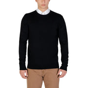 Black crew neck sweater with white collar and beige pants.