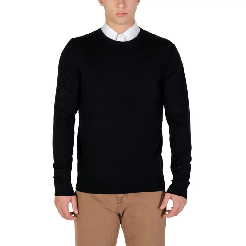 Black crew neck sweater with white collar and beige pants.