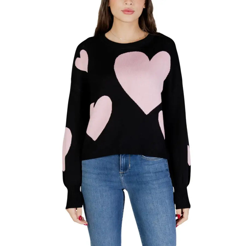 Black long sleeve round neck viscose knit top for women with pink heart patches on a black sweater