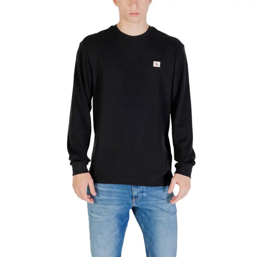 Mann in schwarzem Langarmhemd und blauer Jeans