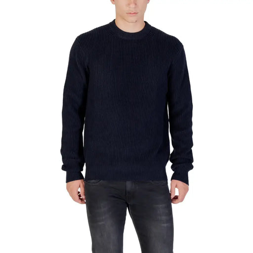 Navy blue ribbed sweater with long sleeves and crew neck.