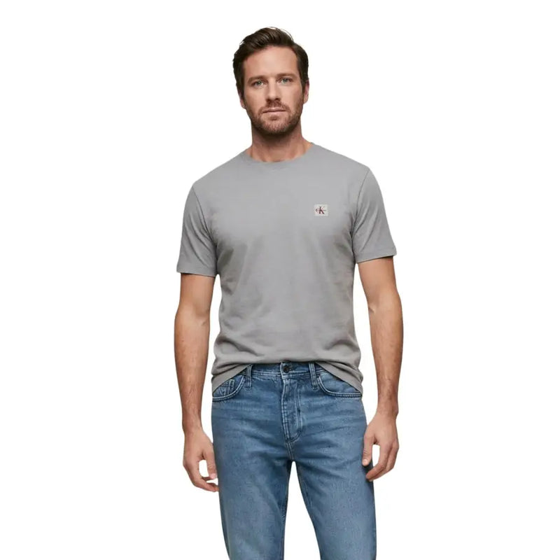 Schwarzer Kurzarm-Rundhalsausschnitt t-shirt in Grau mit einem kleinen roten und weißen Calvin Klein Logo auf der linken Brust