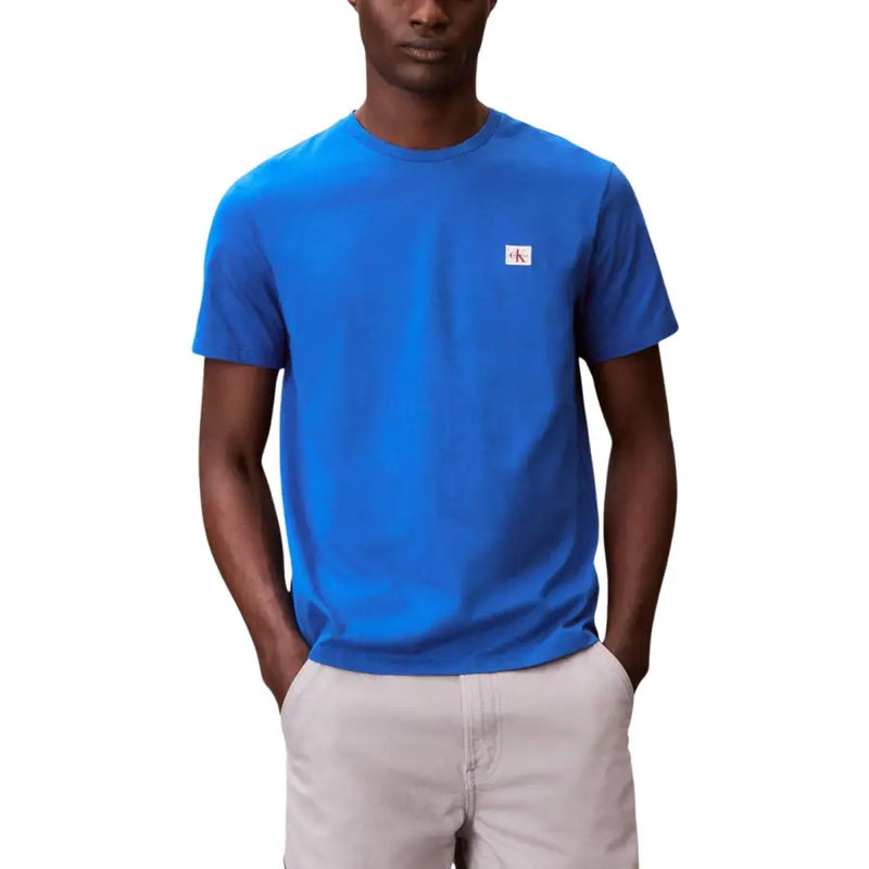 Schwarzer Kurzarm-Rundhalsausschnitt t-shirt mit einem leuchtenden Blau Calvin Klein Stoff mit einem kleinen weißen Logoaufnäher auf der linken Brust