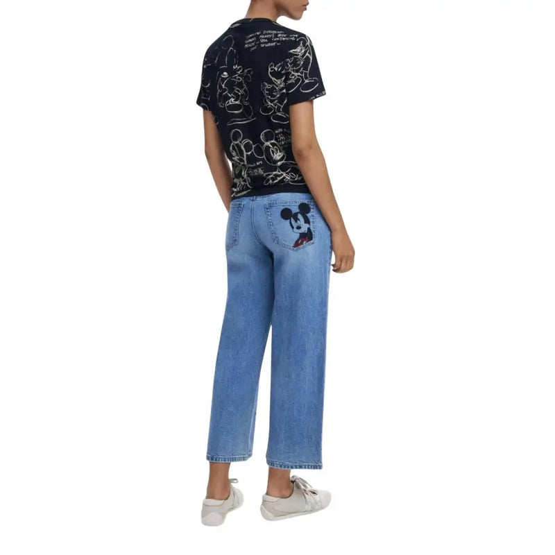 Black short-sleeve Mickey Mouse print T-shirt paired with light blue wide-leg jeans with a Mickey Mouse patch