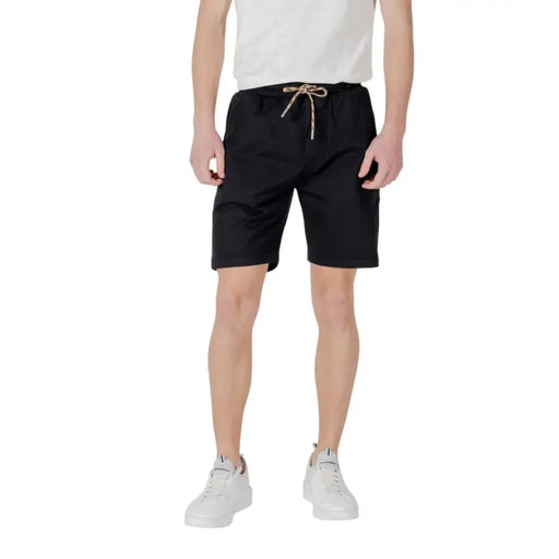 Schwarze Shorts mit Kordelzug, präsentiert in einem hellbraunen Kordelzug Shorts Produktbild