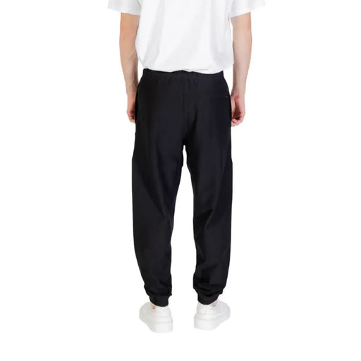 Black Calvin Klein sweatpants with elastic cuffs displayed in a product image