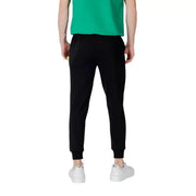 Black sweatpants with elastic cuffs white drawstring and subtle yellow tag on the side seam in comfortable jogger style